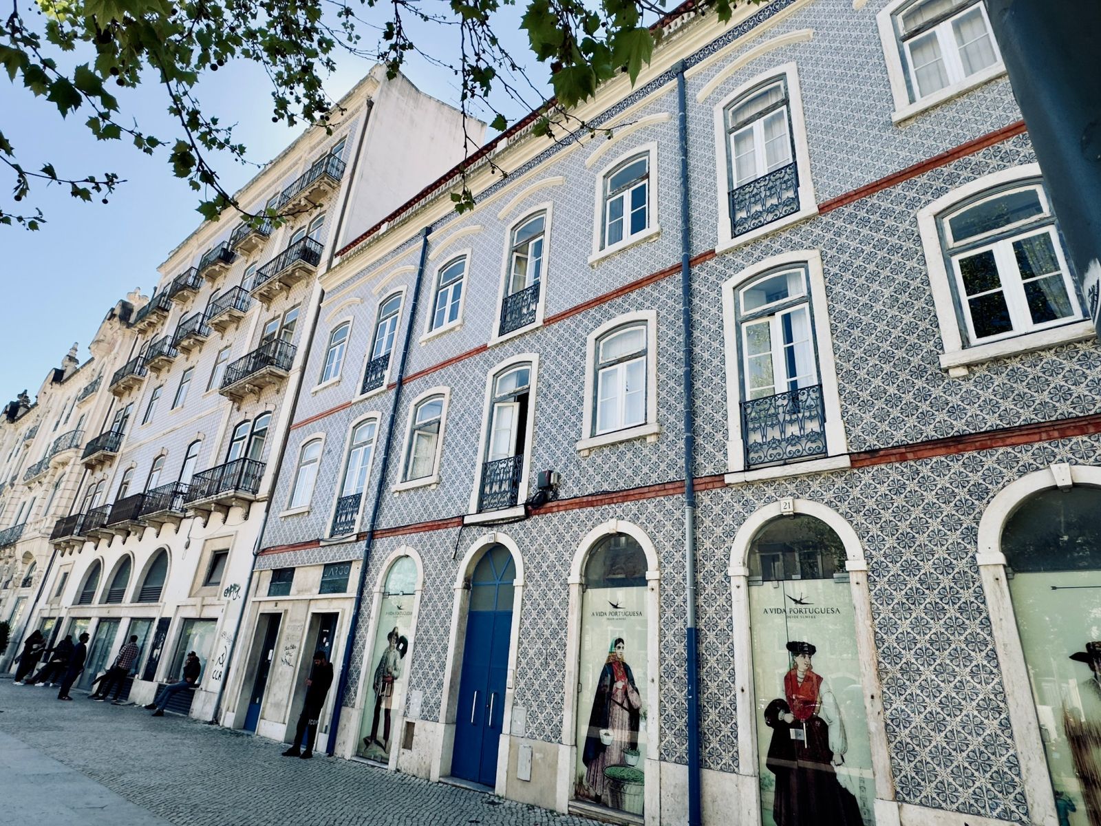 A row of buildings covered in blue-and-white patterned tiles with iron balconies